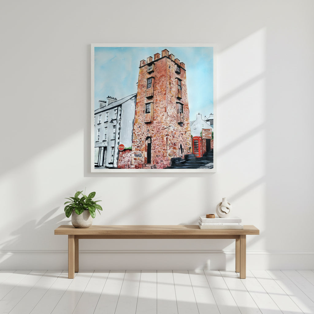 50×50 cm white-framed art print of The Curfew Tower Cushendall positioned above a hallway bench, bright modern home, sunlit interior, high-key aesthetic, premium editorial-style product mock-up.