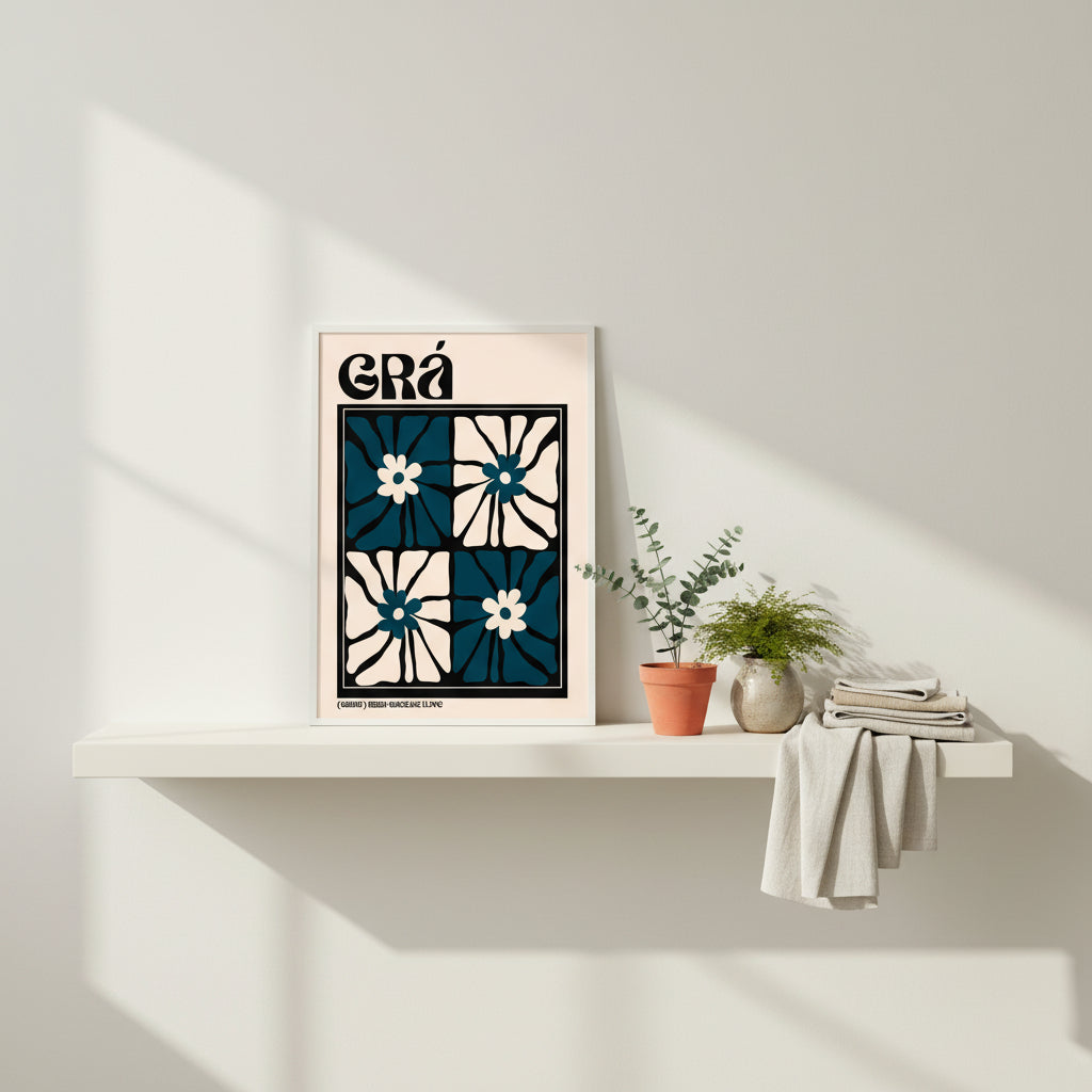 Minimalist studio setting with neutral tones; unframed Grá print leaning casually on a floating shelf beside small potted greenery and Irish linen textiles.